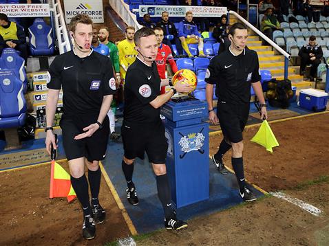 Referee David Webb leads out Posh and Oldham